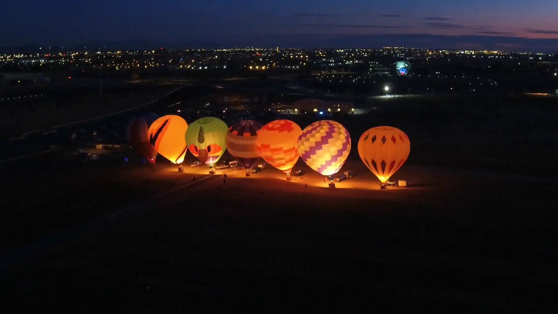 The row of balloons lit at dusk at Balloon Fiesta Park